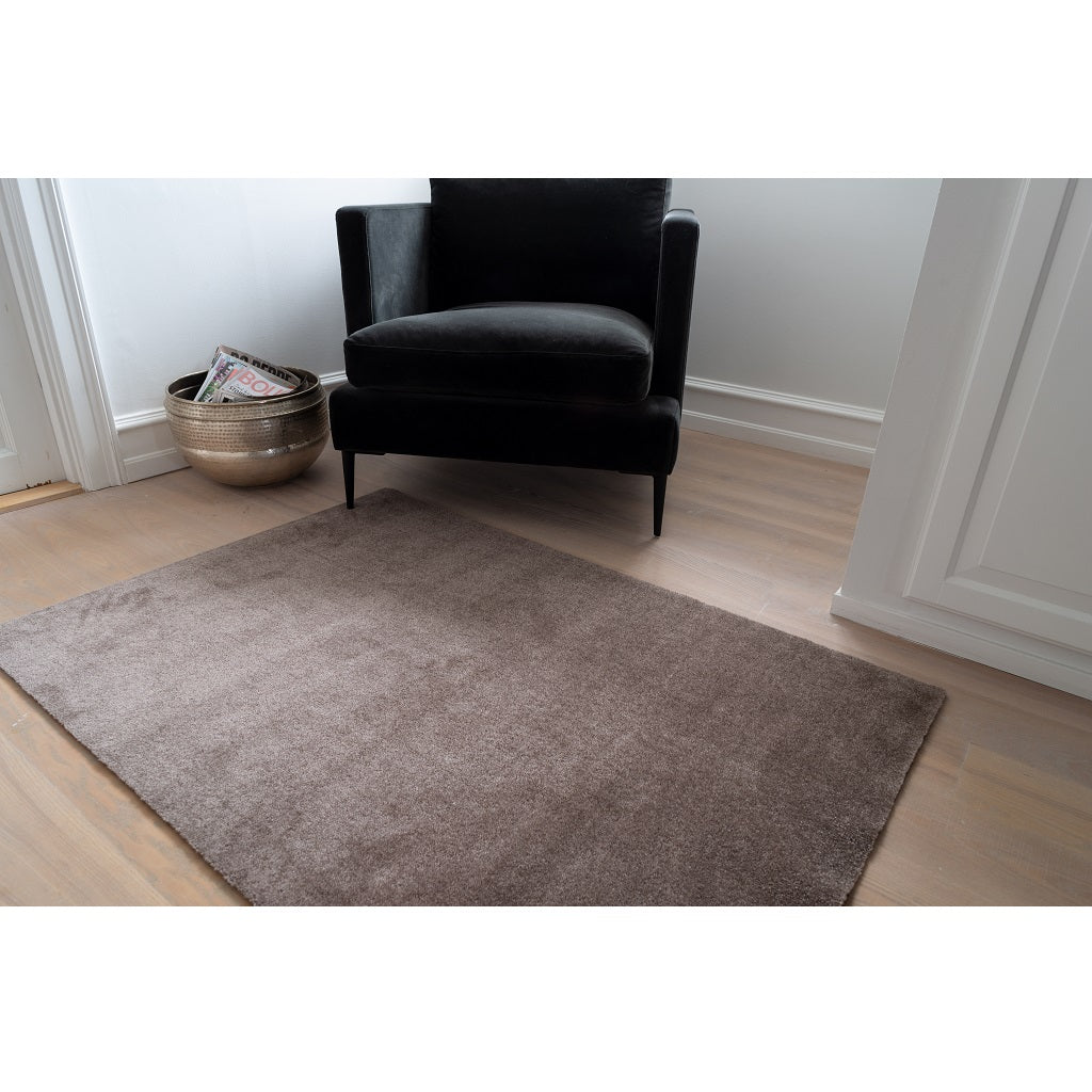 Tica Copenhagen Floormat sand 90x130 på gulvet foran stol